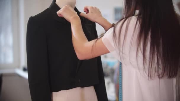 A female designer works with a black jacket — Stock Video