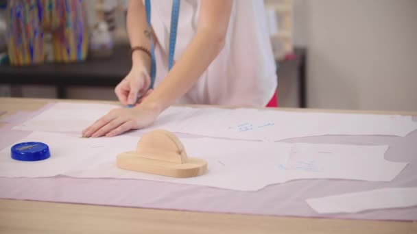 Womens hands measure pieces of cloth on a table — Stock Video