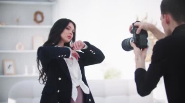 Genç, çekici, modaya uygun, beyaz stüdyoda fotoğraf çeken bir kadın. Orta çekim