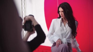 Kırmızı arka planda fotoşopu olan çekici genç bir kadın. Orta çekim