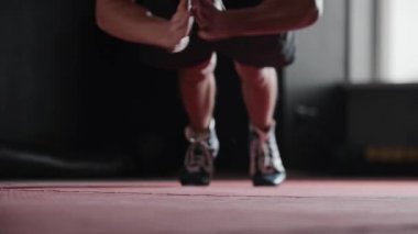 Atletik genç adam ellerini çırparak şınav çeker. Orta çekim