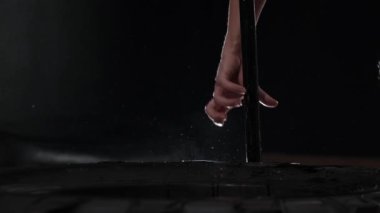 Bir adam büyük lastiğin yanında çekiç alır. Orta çekim