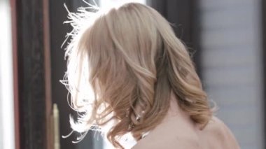 Saçları taranmış güzel bir gelin omuzlarının üzerinden döner ve gülümser. Portre