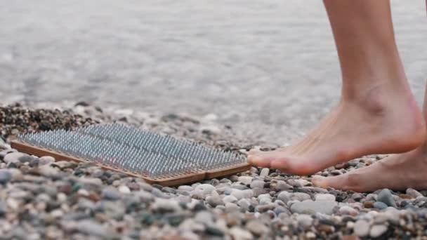 Seorang Wanita Berjalan Papan Kayu Dengan Paku Sadhu Pinggir Laut — Stok Video
