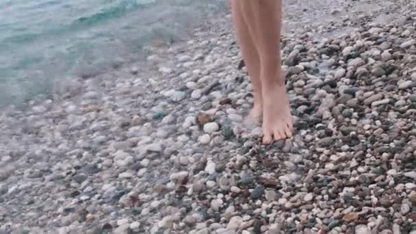 Kobieta Niebieskich Spodenkach Spaceruje Wzdłuż Wybrzeża Kamyczkach Środek Strzału — Wideo stockowe