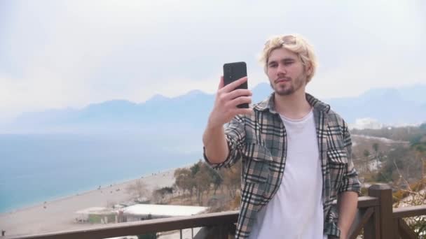 Ung Snygg Man Tar Selfie Bakgrunden Havet Mittskott — Stockvideo