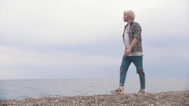 Young Blonde Man Walks Shore Sea Mid Shot — Stock Video