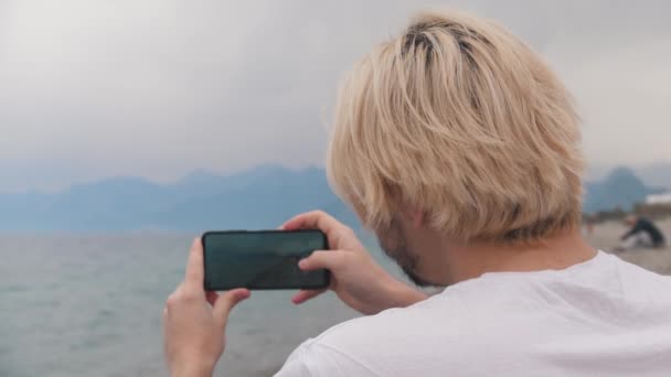 Blondyn Kręci Filmik Błękitnym Morzem Przez Telefon Środek Strzału — Wideo stockowe