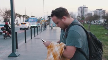 İstanbul caddesinde telefonuna bakan bir gezgin. Orta çekim