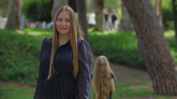 Eine Frau Blickt Die Kamera Während Ihre Töchter Hintergrund Ball — Stockvideo