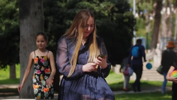 Kvinna Tittar Skärmen Sin Telefon Och Hennes Döttrar Går Fram — Stockvideo