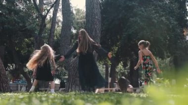 Anne ve iki kızından oluşan mutlu bir aile parkta kovalamaca oynuyor. Orta çekim