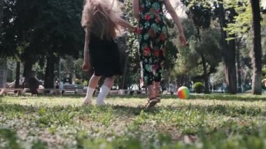 Parkta lastik topla futbol oynayan iki küçük kız. Orta çekim