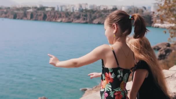 橋の上に立って海を指差している2人の少女 ミッドショット — ストック動画