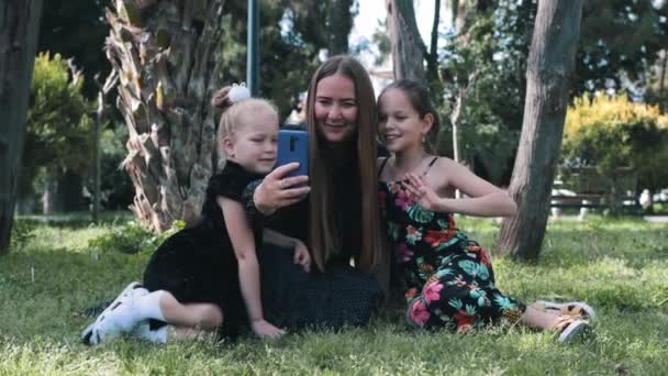 母亲的家人和两个女儿坐在草地上 自私自利 — 图库视频影像