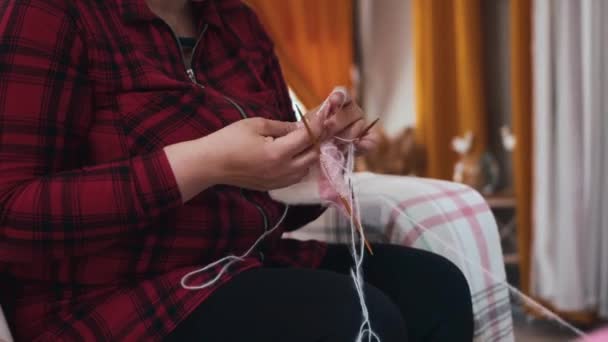 女は編み物の針で小さな服を編む ミッドショット — ストック動画