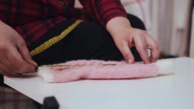 Bir kadın küçük bir parça giysi ölçer. Orta çekim