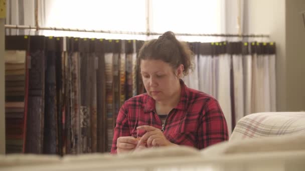 女性は細い糸から小さなピンクの靴下を編んでいる ミッドショット — ストック動画