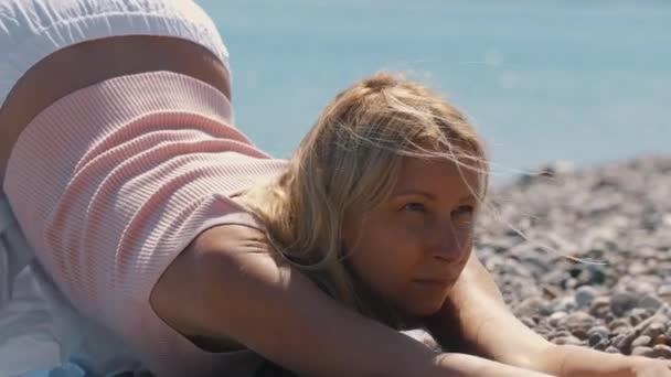 Доросла Блондинка Стоїть Позі Йоги Гальковому Пляжі Середній Постріл — стокове відео