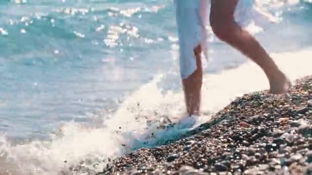 Eine Frau Geht Auf Den Kieselsteinen Und Benetzt Ihre Füße — Stockvideo