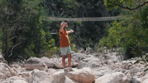 Giovane Uomo Erge Sulle Rocce Selfie Sullo Sfondo Del Ponte — Video Stock