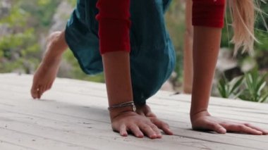 Şevkatli kadın ahşap yüzeyde yoga egzersizleri yapıyor. Orta çekim