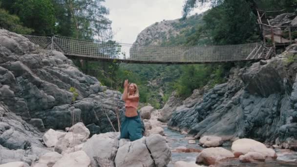 Женщина Делает Медитативные Упражнения Стоя Коленях Скале Посреди Ручья Средний — стоковое видео