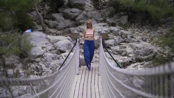 Mujer Rubia Adulta Caminando Por Puente Cuerda Mid Shot — Vídeos de Stock