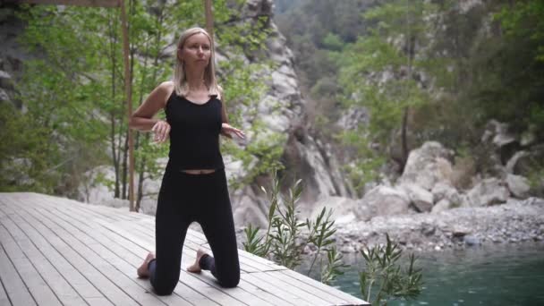 Yoga Junto Lago Una Mujer Vestida Negro Rodillas Haciendo Ejercicios — Vídeos de Stock