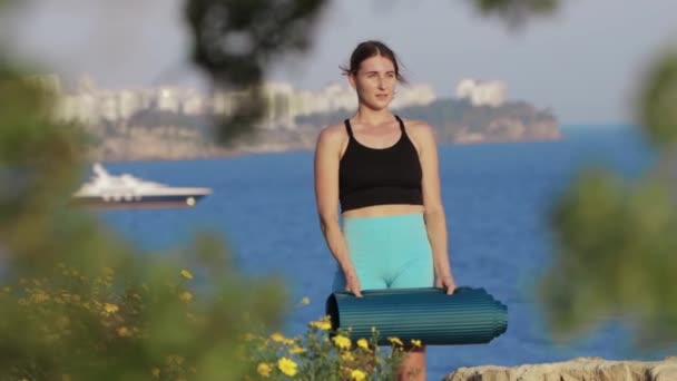 Sport Utendørs Kvinne Som Står Åsen Ved Havet Holder Yogamatte – stockvideo