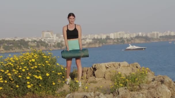 スポーツ屋外 フィットネス女性は海で丘の上にヨガマットを置きます ミッドショット — ストック動画