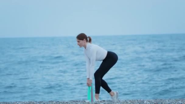 Fitness Outdoors Sportive Woman Exercises Pebble Beach Using Elastic Band — 비디오