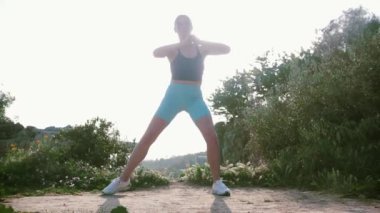 Sportif bir kadın vücudunu dışarıda geriyor. Orta çekim