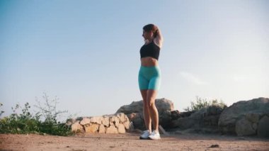 Açık havada ellerini uzatan sportif bir kadın. Orta çekim