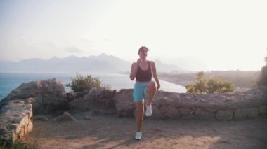 Dışarıda spor yapan genç bir kadın var. Orta çekim