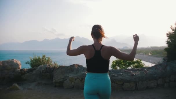 Sportliche Frau Geht Bei Sonnenuntergang Den Rand Des Hügels Meer — Stockvideo