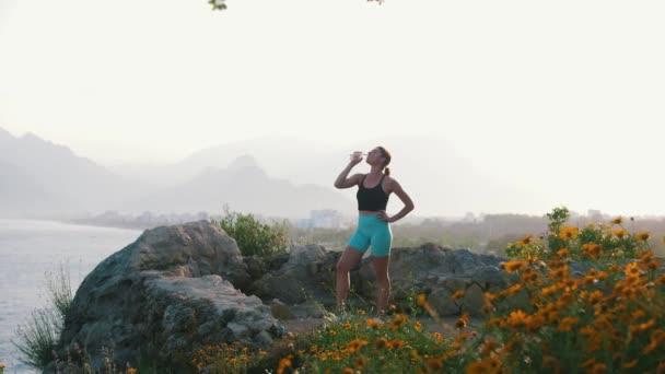 Eine Frau Sportkleidung Trinkt Wasser Auf Einem Hügel Aus Dem — Stockvideo