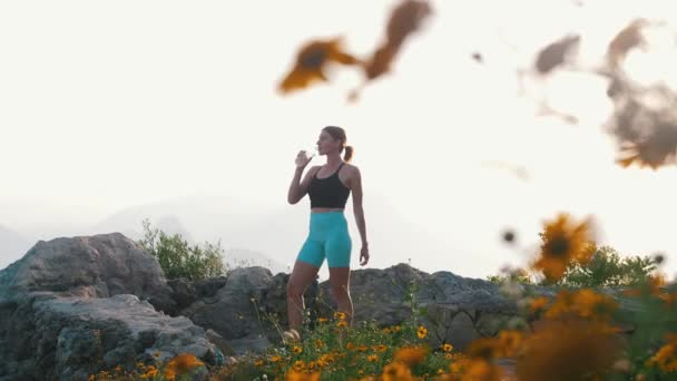 Sportliche Frau Steht Auf Dem Hügel Und Trinkt Wasser Aus — Stockvideo