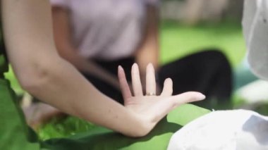 TURKEY, ANTALYA 06-05-2022: Yeşil parkta bir çemberin içinde oturan ve birlikte meditasyon yapan farklı kadınlar. Orta çekim