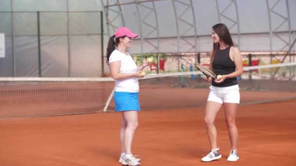 Two Women Stand Tennis Court Playing Balls Rackets Talking Mid — Vídeo de Stock