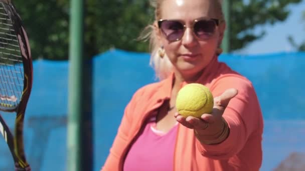 Woman Tennis Coach Showing Ball Hitting Racket Mid Shot — Stockvideo