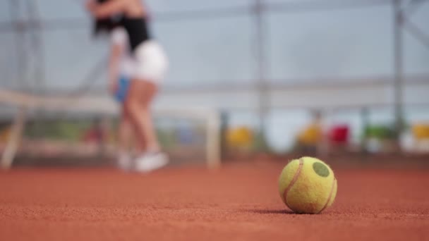 Spor Konsepti Yerde Tenis Topu Arka Planda Isınan Iki Bayan — Stok video
