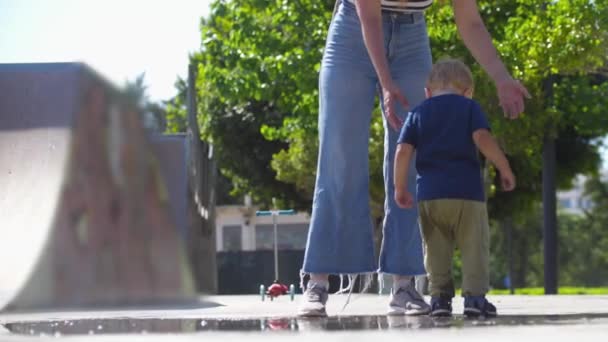 Little Boy His Mother Walking Puddles Skatepark Mid Shot — Video Stock