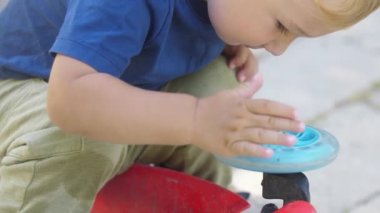 Küçük bir çocuk çocuk mobiletiyle tekerlek çeviriyor. Orta çekim