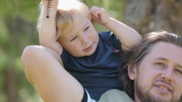 Little Boy Sitting Neck His Father Playing Spring Mid Shot — Stockvideo