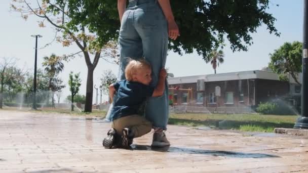 Een Jongetje Met Zijn Moeder Het Park Omringd Door Watersproeiers — Stockvideo