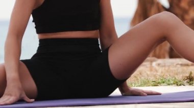 Genç sarışın plastik kadın doğa üzerinde esneme egzersizleri yapıyor. Orta çekim