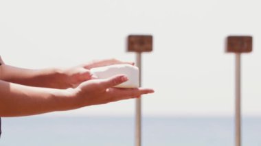 Bir kadın ellerini pudra çubuğuyla ovuyor. Orta çekim