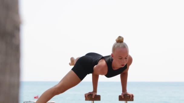 Young Blonde Woman Gymnast Balancing One Hand High Bar Sea — Stock video