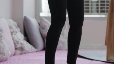 Women standing on the yoga mats and doing yoga movements. Mid shot